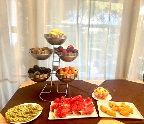 Fruit display and appetizers at VERDI hotel in Jesolo featuring tiered bowls with fresh produce and sliced watermelon