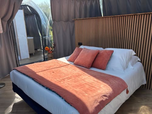 Chambre Bulle Topaze à l'hôtel Bubble Jade avec lit queen-size, literie corail et vue sur le jardin depuis la fenêtre bulle à Bazouges la
