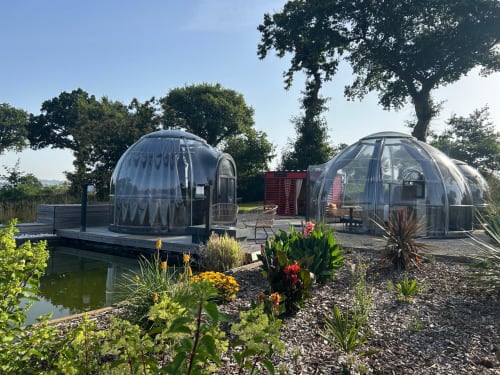 Deux dômes géodésiques du Bubble Jade Hotel à Bazouges la Pérouse avec vues sur jardin, aménagement paysager et salon extérieur