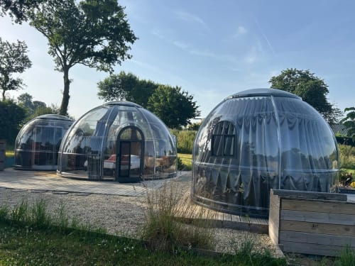 Trois dômes bulles transparentes à l'hôtel Bubble Jade à Bazouges-la-Pérouse, offrant vue sur le jardin et espaces extérieurs privés
