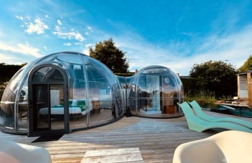Chambre Bulle Émeraude de l'hôtel Bubble Jade : dôme géodésique, vue jardin, Jacuzzi et terrasse en bois.