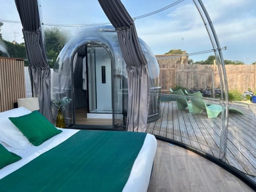 Chambre Bubble Jade à Bazouges la Pérouse avec dôme transparent, literie verte et vue sur le jardin