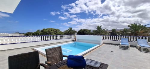 Terraza en la azotea de Villas del Mar con piscina, tumbonas y vistas a las montañas en Puerto Calero