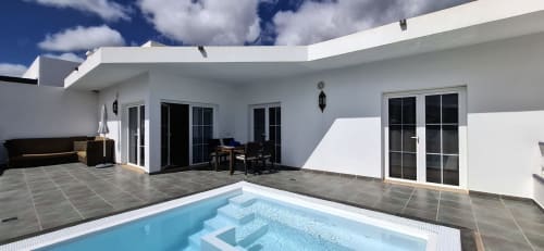 Villa moderna con piscina privada, zona de descanso y puertas de cristal en Villas del Mar Viña y Cabrera, Puerto Calero