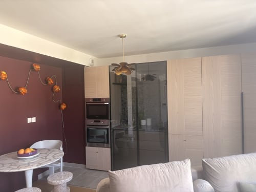 Modern open-plan apartment at Maisons Valmer, Le Havre with burgundy accent wall, integrated kitchen, and sea view terrace