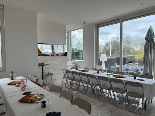 Modern dining room at Villa Bianca B&B in Mortroux Dalhem with marble tables, floor-to-ceiling windows overlooking terrace