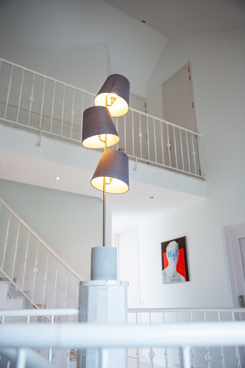 Modern three-tier pendant lamp in Villa Bianca stairwell with white railings and contemporary décor