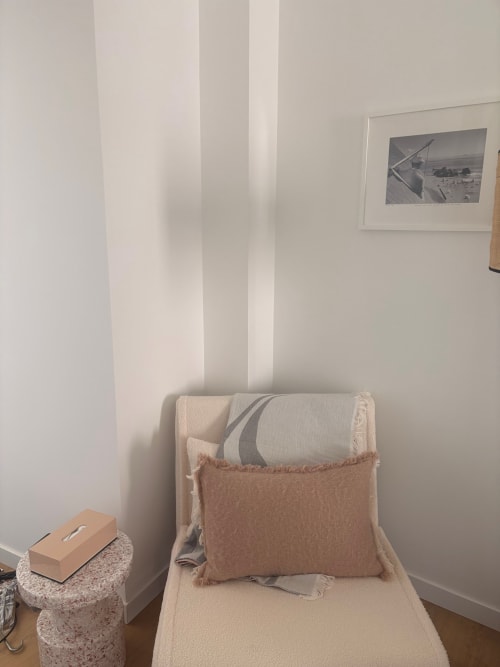 Minimalist bedroom corner at An heol penthouse with cream chair, beige cushion, and framed maritime artwork overlooking Le