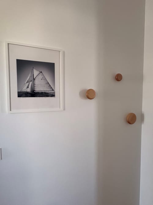 Nautical decor in Le Havre apartment: framed sailing yacht print and wooden wall pegs