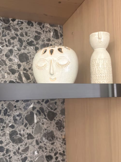 Decorative ceramic face vessels on shelf in An heol penthouse at Maisons Valmer, Le Havre