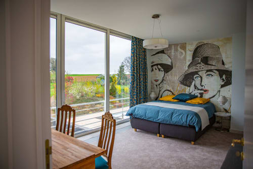 Modern bedroom at Villa Bianca B&B in Dalhem with vintage pop art wall, blue bedding, and countryside views