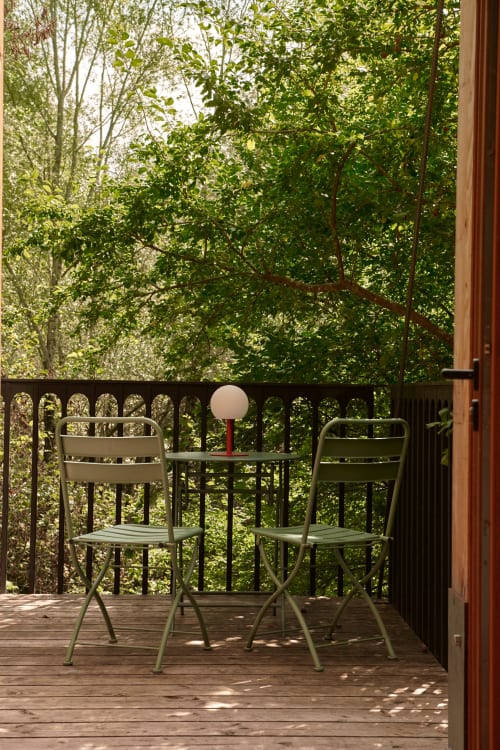 Balcon avec vue sereine sur la forêt à Micro Palaces Vaulx, deux fauteuils verts et petite table