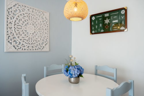 Sala de jantar elegante no apartamento Pêra Breeze do Happy Nest AL com mesa redonda, hortênsias azuis, luminária de fibra trançada e