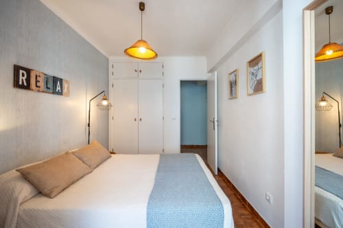 Quarto moderno da Happy Nest AL em Armação de Pêra com cama de casal, iluminação pendente e vista para a cidade