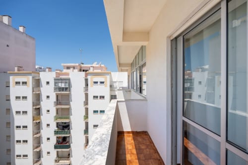 Vista da varanda do Happy Nest AL em Armação de Pêra com edifícios brancos sob céu limpo