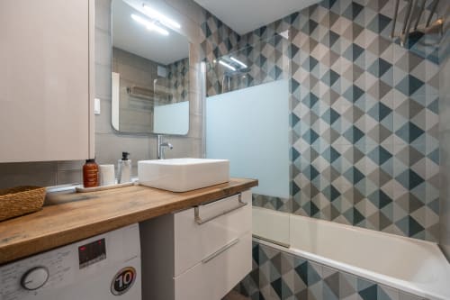 Banheiro moderno do apartamento Pêra Breeze na Happy Nest AL, Armação de Pêra, com azulejos geométricos, cuba suspensa e chuveiro