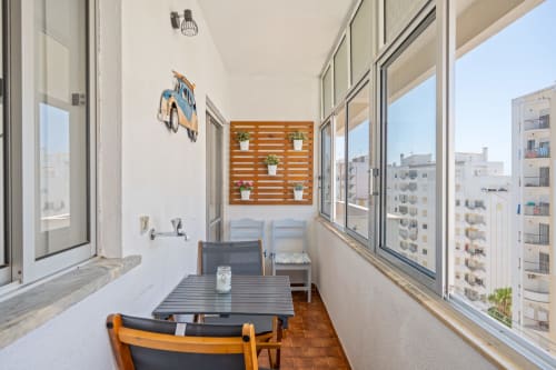 Varanda com vista para a cidade no Happy Nest AL em Armação de Pêra, Portugal, com mesa de refeições, cadeiras e móveis modernos