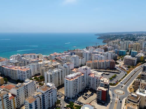 Vista da cidade costeira de Armação de Pêra com Mar Mediterrâneo, edifícios brancos e falésias rochosas