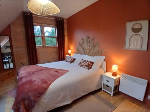 Chambre douillette à Ma Cabane du Canada à Combray avec murs orange, lit queen-size, vue montagne et éclairage chaleureux