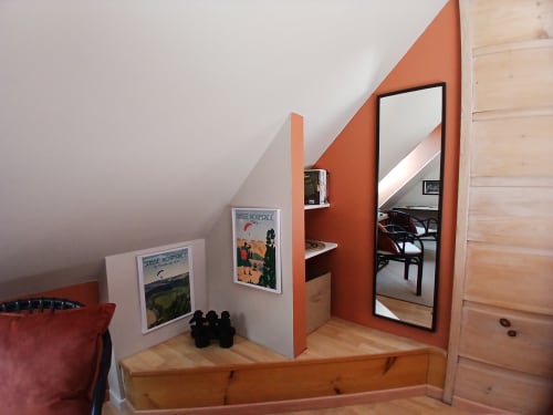 Chambre douillette sous les toits à Ma Cabane du Canada avec mur orange, miroir et affiches vintage à Combray, France