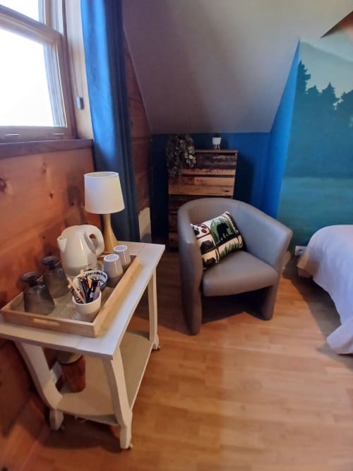Chambre Vancouver à Ma Cabane du Canada avec salon partagé, fauteuil gris, lampadaire et décoration murale vue montagne