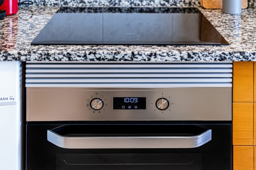 Forno embutido com painel de controle em aço inoxidável e display digital na cozinha do apartamento Mar Azul em Happy Nest AL, Armação