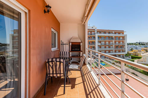 Ampla varanda no Happy Nest AL com terraço, paredes laranja e vistas do jardim em Armação de Pêra