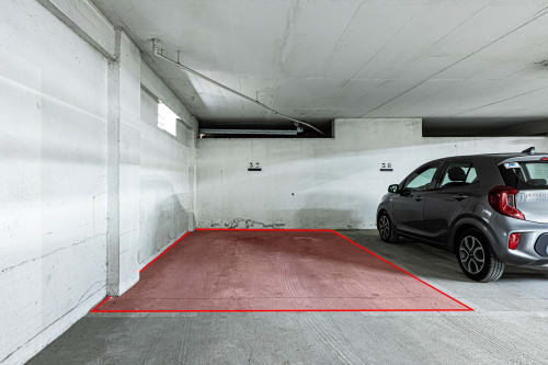Lugar de estacionamento subterrâneo com linhas vermelhas de delimitação em Happy Nest AL, Armação de Pêra
