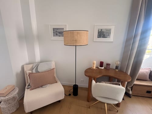 Stylish seating area at Maisons Valmer Le Havre with cream chairs, wooden accent table, floor lamp, and harbor view curtains