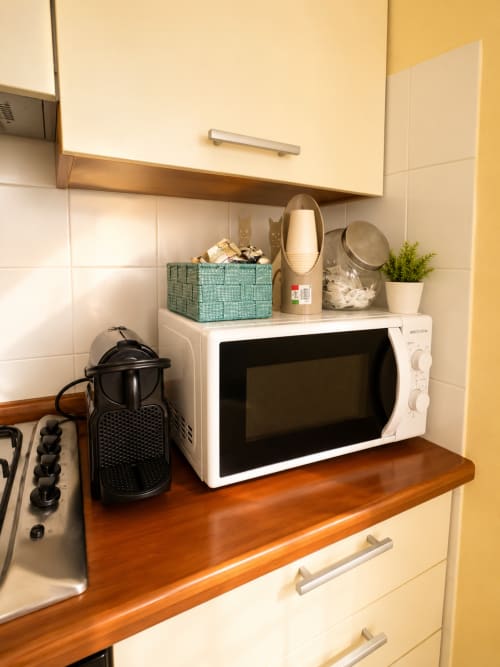 Angolo cucina di Bicocca Flat Milano con microonde, caffettiera e elettrodomestici compatti