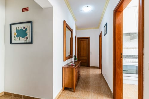 Corredor do apartamento Marina Rocha no Happy Nest AL, Portimão, com portas em madeira e acesso à vista da cidade