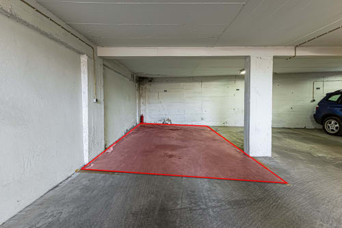 Garagem de estacionamento subterrânea do Happy Nest AL em Portimão com lugar de parque marcado e contornado a vermelho