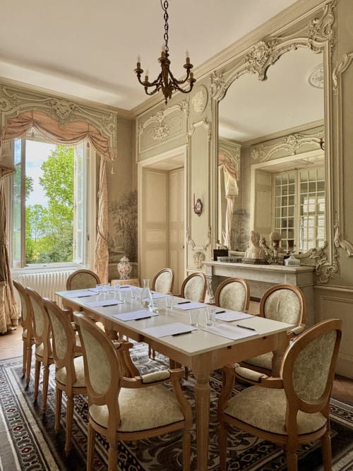 Salle à manger élégante du Château de Saint Thomas avec boiseries crème ornées, lustre et table dressée formellement
