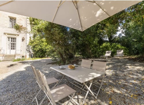 Terrasse extérieure du Château De Saint Thomas avec parasols, table de dining et verdure luxuriante à Saint-Étienne-de-Montluc