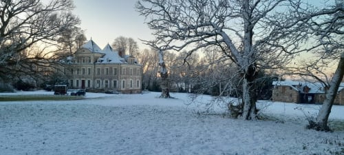 Château de Saint Thomas recouvert de neige à Saint-Étienne-de-Montluc, arbres nus et sol givre à l'aube