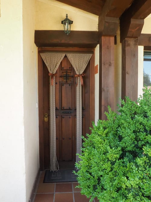 Rustic wooden door with beaded curtains at Rural Senda del Duratón Apartments entrance in Sebúlcor, Spain