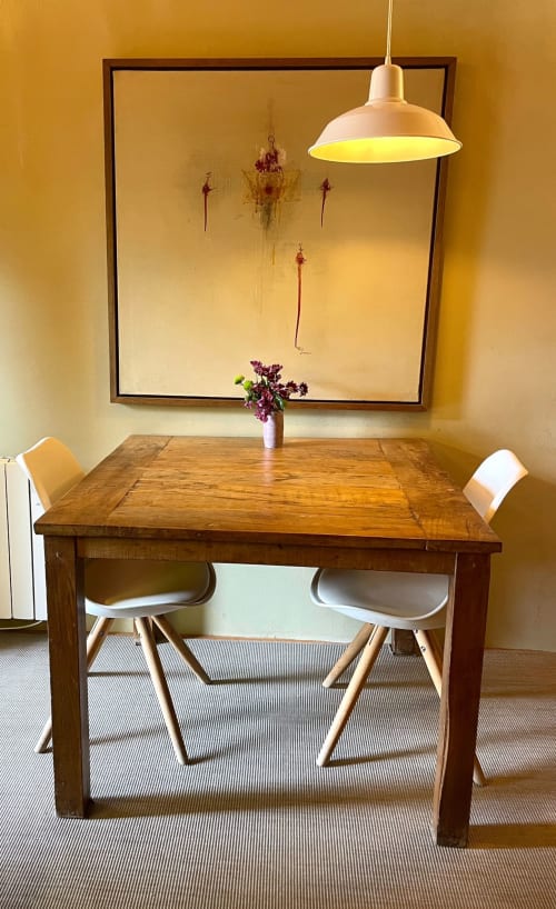 Comedor en Apartmentos Rectoria de Regencós con mesa de madera, sillas blancas, lámpara colgante y arreglo floral