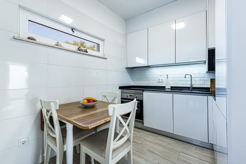Cozinha branca moderna com mesa de jantar na casa de hóspedes Happy Nest AL em Pêra, Portugal