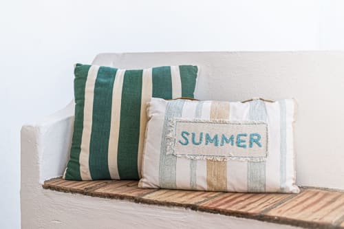 Almofadas decorativas com padrão listrado no sofá creme da propriedade Happy Nest AL em Pêra, Portugal