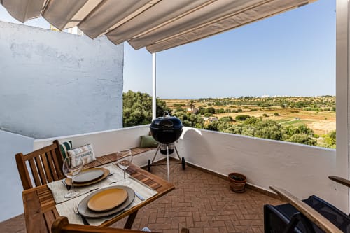 Terraço Casa Passarinho no Happy Nest AL com área de refeições, churrasqueira e vistas rurais perto de Pêra, Portugal