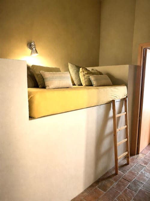 Lit mezzanine avec literie et oreillers jaunes dans une chambre lumineuse aux Apartmentos Rectoria de Regencós
