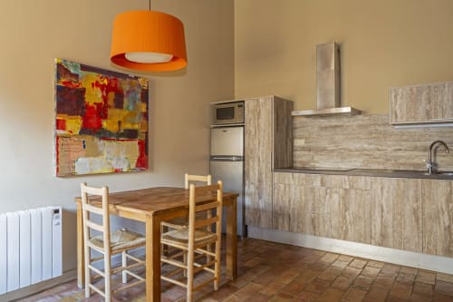 Cocina-comedor moderno en Apartmentos Rectoria con mesa de madera, sillas y gabinetes beige