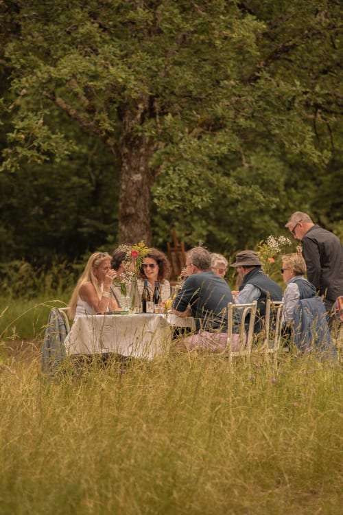 Freiluftdining bei La Maison George in Burgund mit Gästen an einem Tisch in ländlicher Umgebung