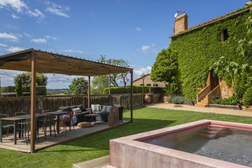 Cottage en pierre rustique aux murs couverts de lierre, piscine privée, pergola en bois et jardin aménagé à Costa Brava