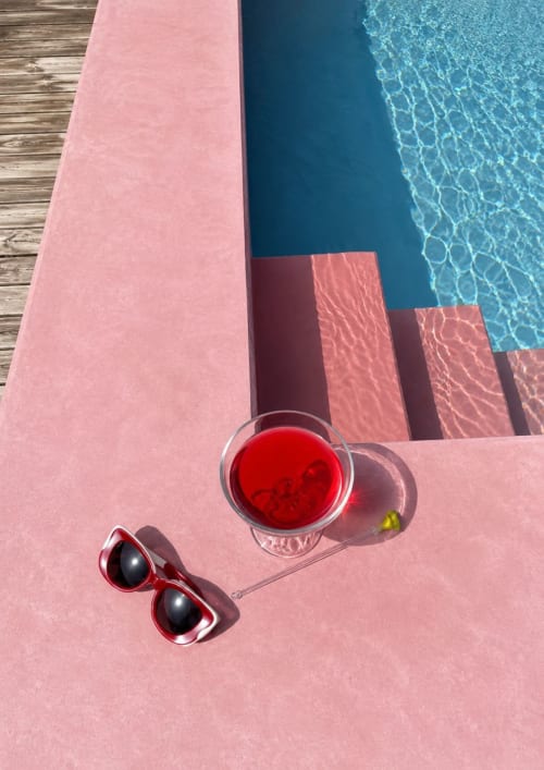 Lunettes de soleil rouges et cocktail au bord de la piscine d'une maison de location à Costa Brava