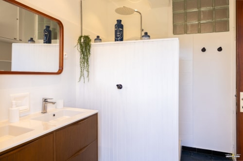 Salle de bain contemporaine à la Villa Annonciade à Centuri avec vasque en bois, douche à effet pluie et carrelage blanc minimaliste
