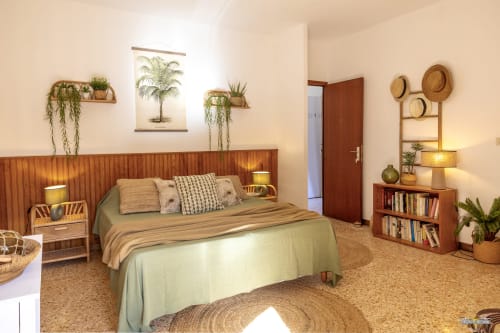 Chambre bohème chaleureuse à la villa La Conciergerie du Cap Corse avec tête de lit en bois, plantes et sol en liège naturel