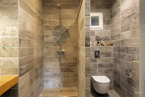 Salle de bain moderne avec douche à l'italienne en pierre et toilettes à la Villa Annonciade, Centuri Corse