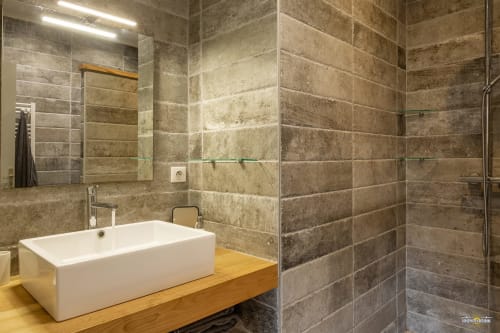 Salle de bain contemporaine de la Villa ANNONCIADE, Centuri avec vasque blanche, murs en travertin et douche à l'italienne