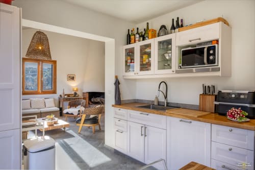 Cuisine moderne de la Villa ANNONCIADE à La Conciergerie du Cap Corse, Centuri, avec mobilier blanc et plan de travail en bois
